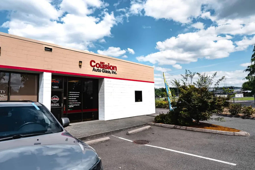 The Cedar Mill shop from the parking lot, with the red Collision Auto Glass sign above the roller door