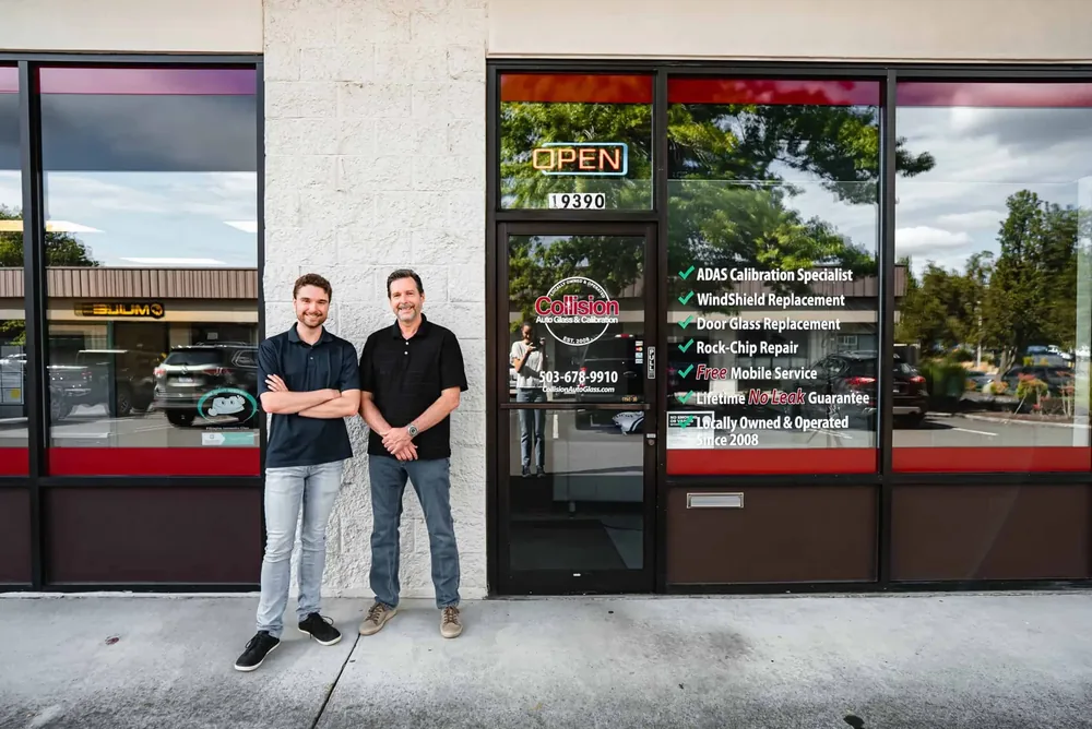 Two staff outside the Tualatin shop, the window behind them listing the services offered