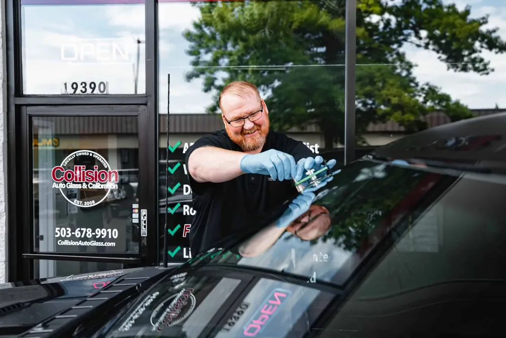 A technician working on a windshield in front of the Tualatin shop window
